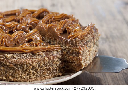 Cake with honey shortcakes, cream boiled condensed milk and sprinkle with nuts