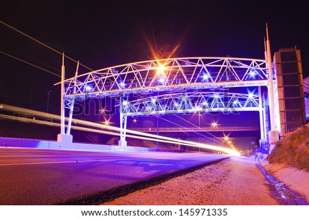 Toll gate on the road with purple lights