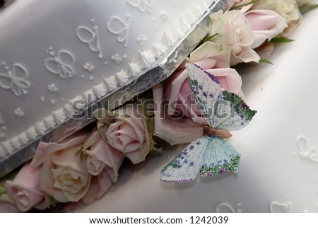 White wedding cake with roses and butterfly.