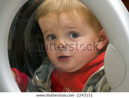 Young cute boy doing the laundry while pushing face against door