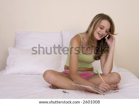 Beautiful blond teenager chatting on cell phone and making appointment