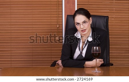 Brunette business woman with black suit with glass of wine
