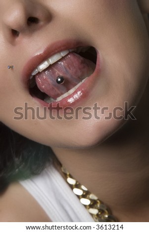 Attractive young woman sticking out her tongue to show piercing