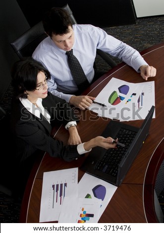 Business workgroup interacting in a boardroom setting using laptop