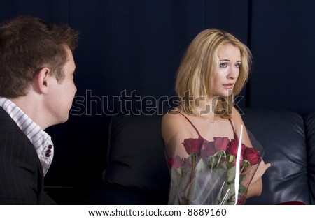 Man giving roses as gift to an upset blond girl who is ignoring him