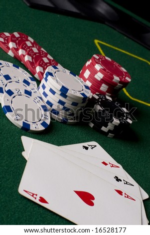 Playing poker cards and several casino chips spread on a green poker table