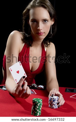 Attractive woman playing poker at a red poker table wearing red dress