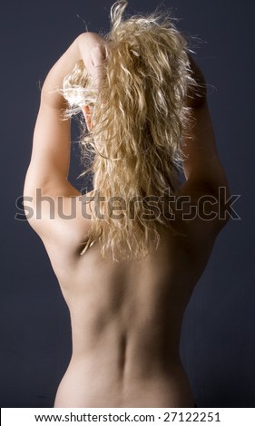 Attractive curly blond with her naked back both hands in hair