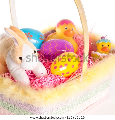 Easter Bunny and Easter basket with eggs and rubber ducks. Isolated on white background