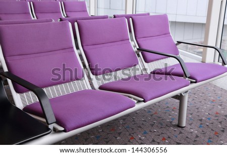 row of purple chairs in the airport
