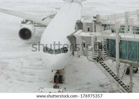 CHITOSE JAPAN FEBRUARY 16 2014: Thai Airways plane ready for boarding in the snow storm on 16 February 2014. Thai Airways just open the new route to Sapporo recently.
