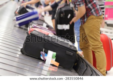 blurred image of people picking up suitcase on luggage conveyor belt in the t airport