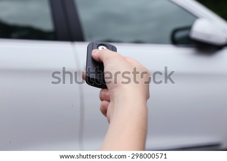 close up on a hand using car key to open the car