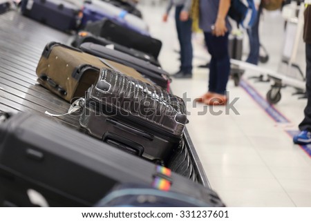 image of people picking up suitcase on luggage conveyor belt in the  airport