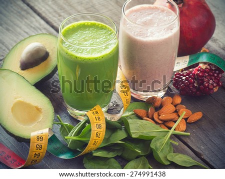 two fresh blended fruit smoothies made with avocado, pomegranate, spinach and almonds