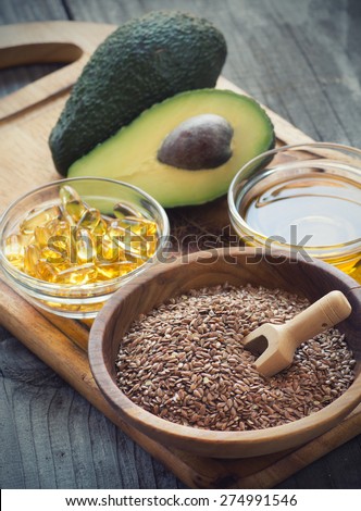 Sources of omega 3 fatty acids: flaxseeds, avocado, oil capsules and flaxseed oil
