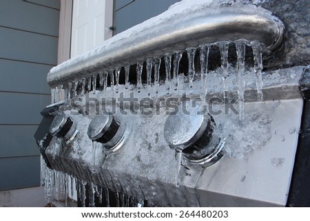 Outdoor barbecue grill covered in ice