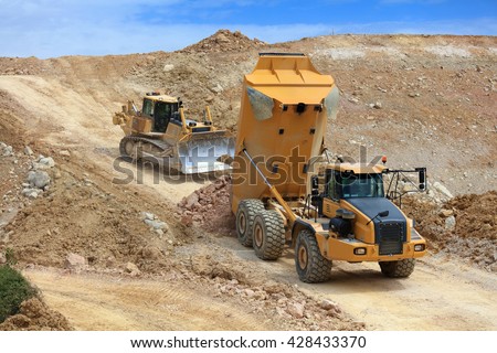truck dumper and bulldozer in action in a quarry