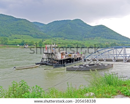 SPITZ AN DER DONAU, AUSTRIA - 16 July 2014: A ferry is crossing the river Danube. The Wachau Cultural Landscape is an excursion destination and a UNESCO World Heritage.