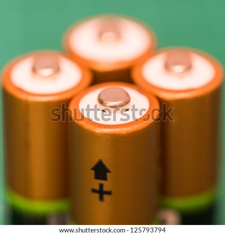 A macro shot of the positive terminals of a foursome of batteries.