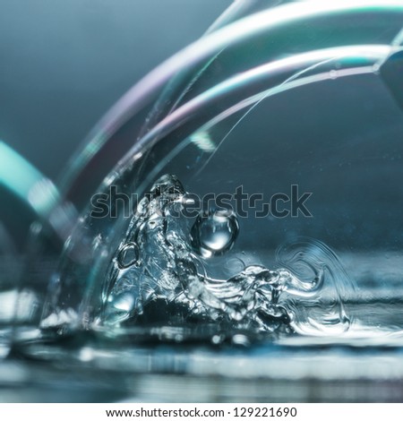 A macro shot of a water splash inside a soap bubble.