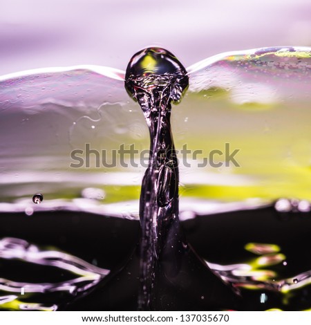 An abstract macro shot of a water spike between two soap bubbles.