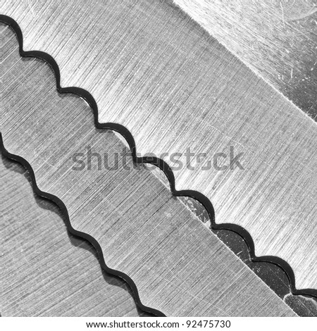 An abstract shot of knife blades resting on top of each other.