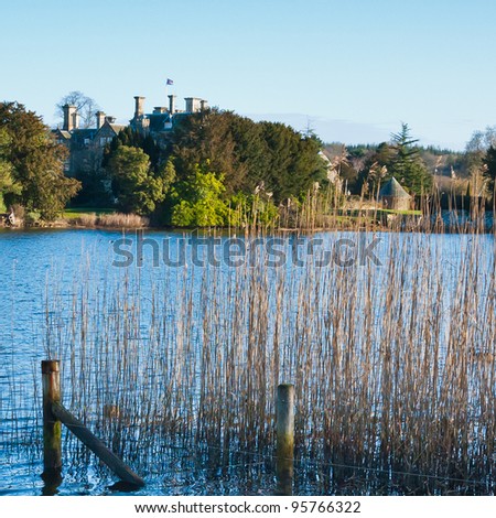Looking through the long grasses across Mill pond towards palace house at Beaulieu.