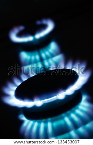 Beautiful kitchen blue gas flames burning, with dark background. Great for cooking and energy themes.