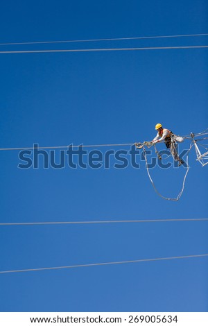Worker repairing a high voltage industrial power energy line. Great for energy, safety and technology themes. : Almada, Portugal - October 02, 2008