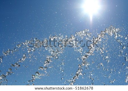 Close-up of water in motion, with beautiful blue sky. Great for summer, freshness and cosmetic themes.