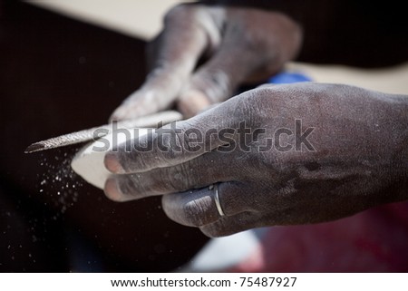 African hands working a stone