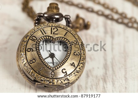 Nice vintage pocket watch on wooden background