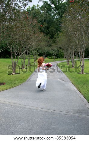 A beautiful redheaded bride running away, or rushing late