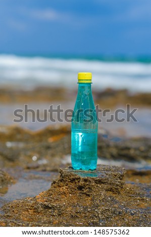 pet bottle with water on the sea sand
