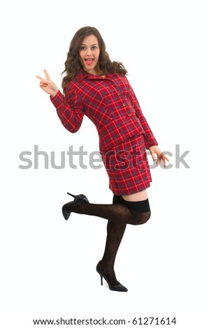 Attractive brunette woman in red suit pants standing on white holding up to fingers to show the peace sign