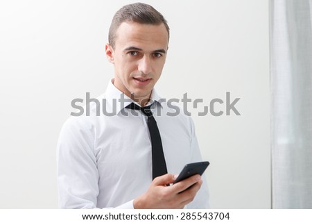 Portrait of employee texting on mobile phone in office