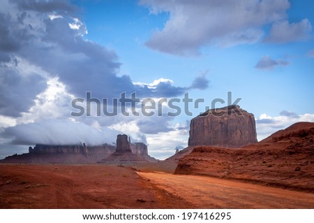 Monument valley road with big thunder cloud in background. Sandstone formation in Monument Valley during sunset.