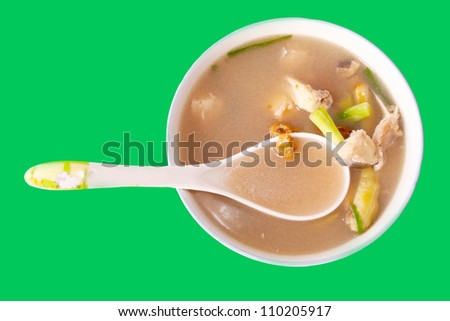 Plate with a Laotian fish soup on green background
