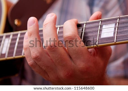 Man\'s hand, playing the guitar