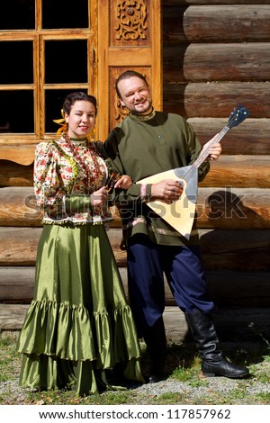 Slender boy with balalaika and beautiful Russian girl in national costume