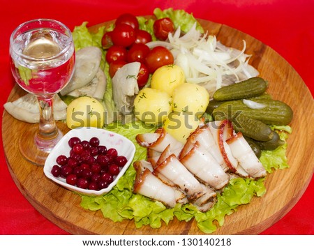 Rustic appetizer with vodka tomato, bacon, pickles, mushrooms, potatoes and herring