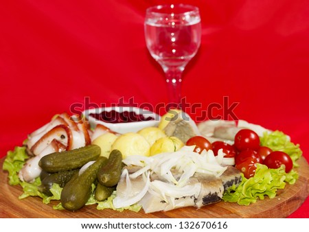Rustic appetizer with vodka tomato, bacon, pickles, mushrooms, potatoes and herring
