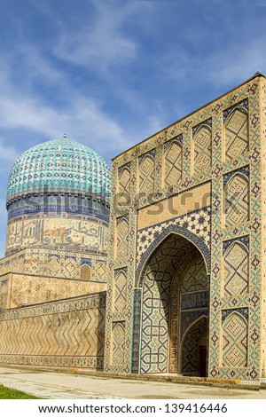 A large gate and a tower with a dome of an ancient madrasah in Samarkand, Uzbekistan