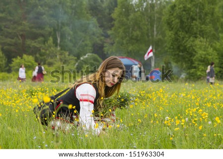 TALTSY, RUSSIA - JUNE 22: Belarusian girls in the Irkutsk region gather flowers and making wreaths during the celebration of the ancient pagan festival Kupalle June 22, 2013 in Taltsy, Russia