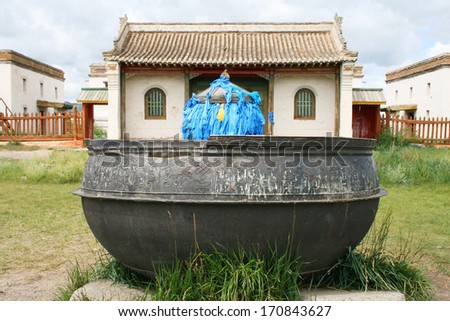 Large cauldron and old earthen building in the grounds of a Buddhist monastery