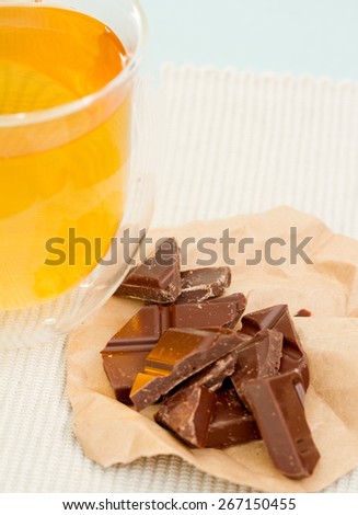 A cup of green tea and chocolate pieces