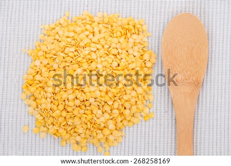 Wooden spoon with yellow lentils