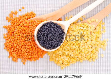 Wooden spoons with black, red and yellow lentils