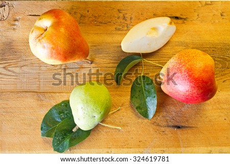 Whole and slice of ripe pears and green pear on a blackboard